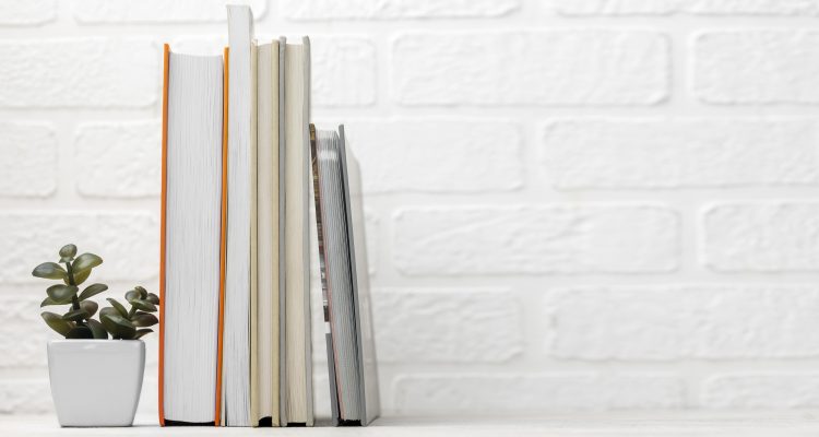 Books placed on the table with a little vase